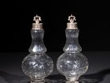 two clear glass salt and pepper shakers on a black surface