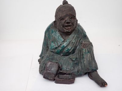 une statue représentant un homme assis par terre