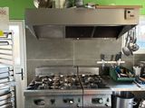 a kitchen with a stove, oven, and pots on the counter