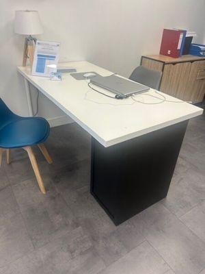 a desk with a computer on it and a blue chair