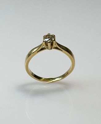 a close up of a diamond ring on a white surface