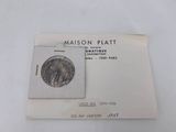 an image of a piece of silver coin sitting on top of a piece of paper
