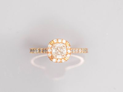 une bague en or jaune sertie d'un diamant rond au centre, entouré de petits diamants blancs