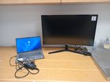 un ordinateur portable posé sur un bureau à côté d'un moniteur