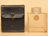 une vieille bouteille d'eau de Cologne posée à côté d'un petit étui sur une table