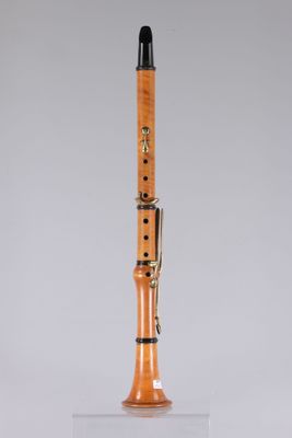 a close up of a wooden clarinet on a clear surface