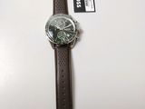 the watch has a brown leather strap and a black face