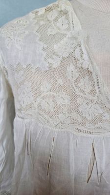 un gros plan sur un chemisier blanc de femme orné de dentelle