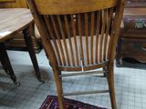 a wooden chair sitting on a rug in a room