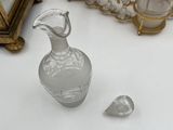 a small glass vase sitting on a table next to a mirror