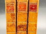 three old books are stacked on top of each other on a table