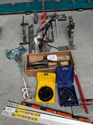 une boîte à outils posée par terre à côté d'une paire de ciseaux
