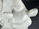 a white elephant figurine sitting on a black surface