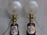une paire de lampes anciennes ornées de fleurs peintes sur fond blanc