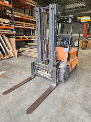 un chariot élévateur dans un entrepôt où il y a beaucoup de bois