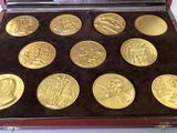 nine gold coins in a case on a table