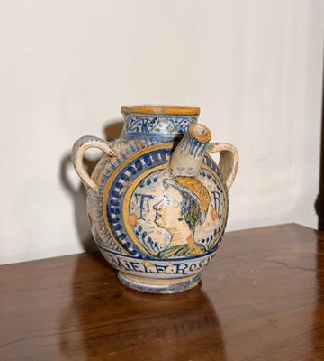un vase bleu et jaune posé sur une table en bois