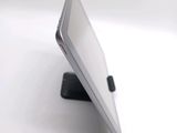 a tablet computer sitting on a stand on a white surface