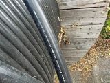 a black hose sitting on the side of a wooden fence