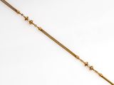 a gold plated necklace with a long chain that has been set on top of a white surface