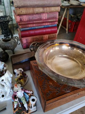 a silver bowl sitting on top of a table next to a pile of books