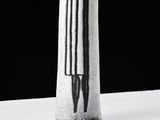 a black and white picture of a vase with a knife in it