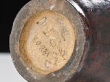 a close up of a brown vase with a black background