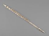 a silver flute with a wooden handle on a gray surface