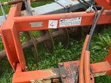 a tractor with a plow attached to it in the grass