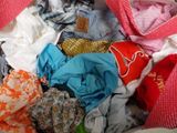 a pile of clothes in a bag on a bed
