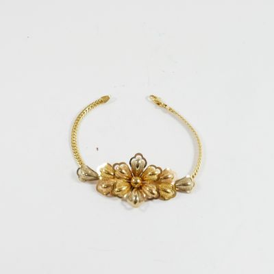 un gros plan d'un bracelet en or orné de fleurs