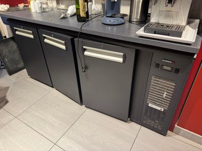 un comptoir sur lequel sont posés une machine à café et un ordinateur portable