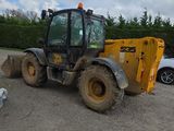 une photo d'un petit engin de chantier garé sur un parking