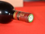 a bottle of wine sitting on a red table cloth