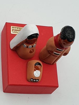 deux figurines représentant un homme et une femme assis sur une boîte rouge