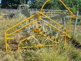 une structure métallique jaune au milieu d'un champ herbeux