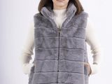 a woman wearing a grey vest and white sweater