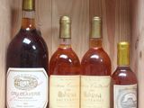several bottles of wine sit in a wooden box on a shelf