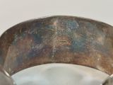 a close up of a silver bracelet on a table