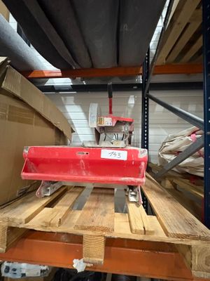 un objet rouge posé sur une palette dans un entrepôt