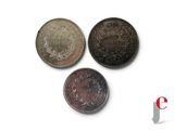 three different types of coins sitting on top of a white surface