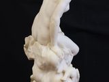 a white statue of a man sitting on top of a table