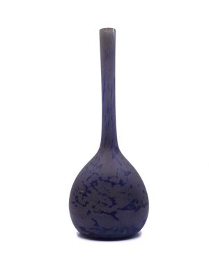 un vase bleu posé sur une surface blanche