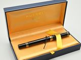 un stylo noir dans une boîte ornée d'un ruban jaune