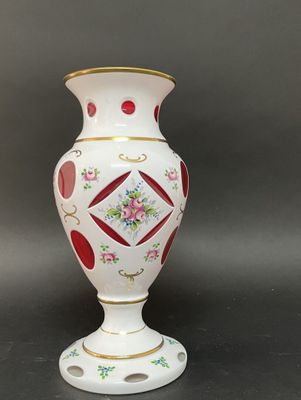 un vase blanc orné d'un motif rouge et jaune