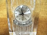 une horloge en verre posée sur une table