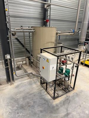 une machine située à l'intérieur d'un bâtiment, équipée de tuyaux et de vannes