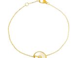 a gold plated bracelet with a white mother of pearl disc