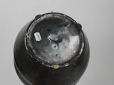 a close up of a black vase with a tag on it