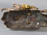bronze figurine of a woman on a rock with a bird on it